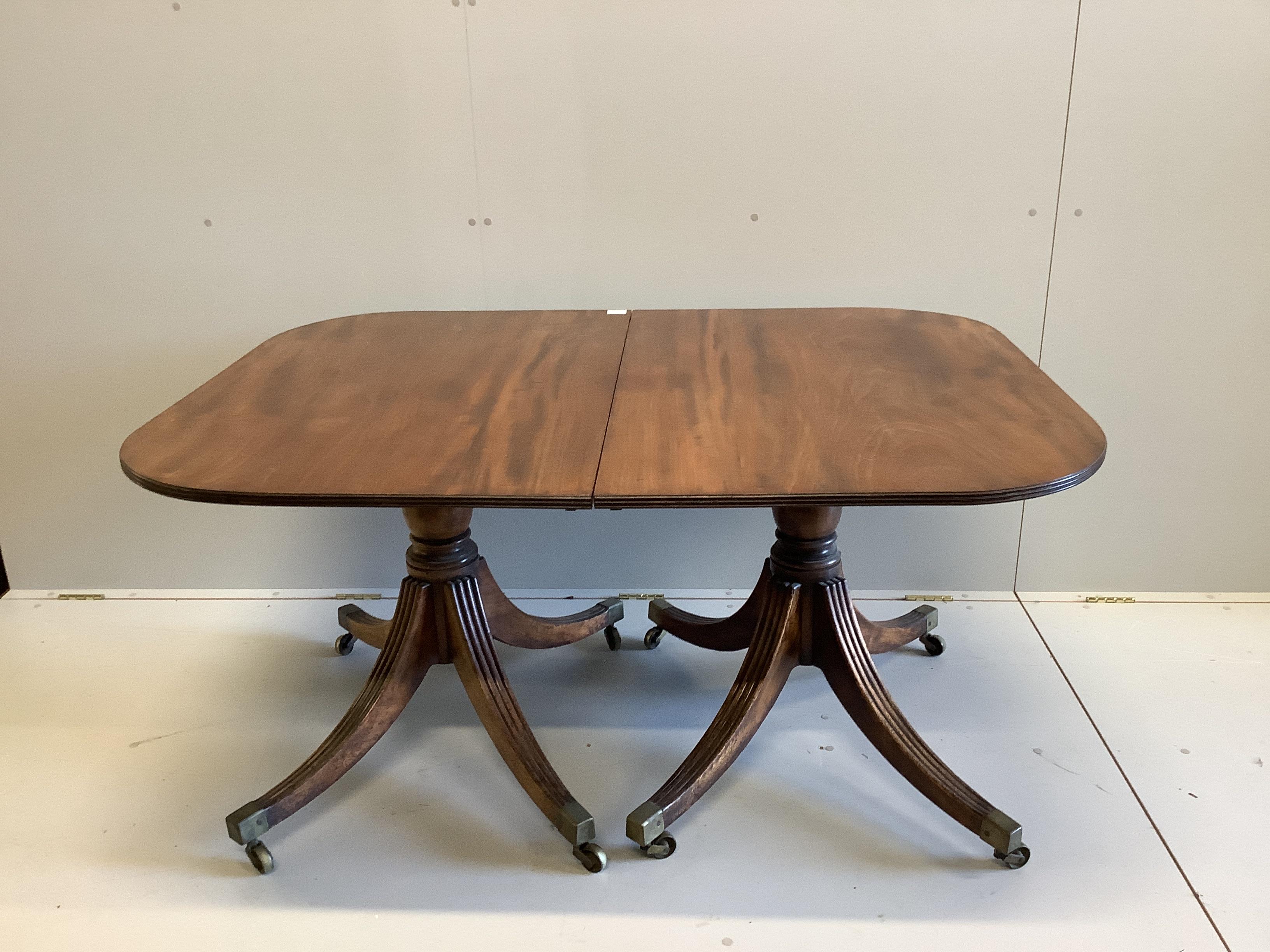 A Regency mahogany two pillar dining table, with one spare leaf. Length 206cm extended, depth 107cm, height 72cm.